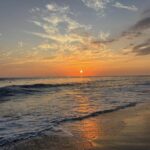 Sunset over Jaco Beach, Costa Rica, with waves along the Pacific coast